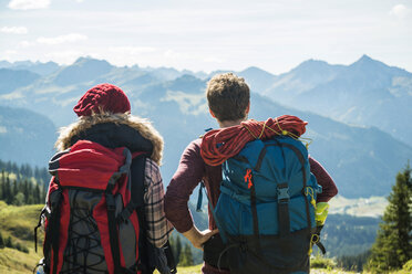 Austria, Tyrol, Tannheimer Tal, young couple in mountains looking at view - UUF002459