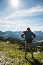 Austria, Tyrol, Tannheimer Tal, young man in mountains looking at view - UUF002460