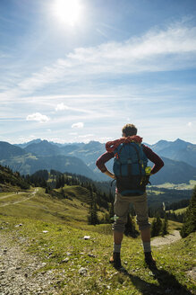 Österreich, Tirol, Tannheimer Tal, junger Mann in den Bergen mit Blick auf die Aussicht - UUF002460