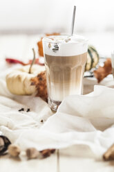 Ein Glas Kürbisgewürz-Latte Macchiato zwischen herbstlicher Dekoration - SBDF001356