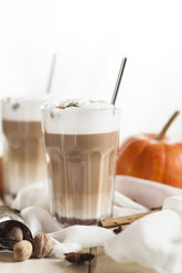 Glas Kürbisgewürz-Latte Macchiato und Gewürze auf Tuch - SBDF001385