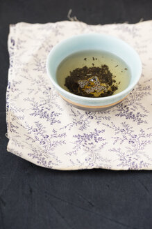 Schale mit Earl-Grey-Tee, gemischt mit Kornblumen auf gemustertem Tuch - MYF000668