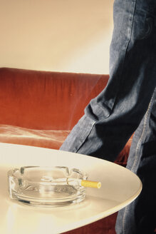 Zigarette im Aschenbecher und vorbeigehende Frau - UWF000215