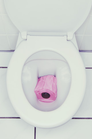 Rosa Toilettenpapier in der Toilette, lizenzfreies Stockfoto