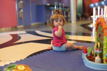 Baby girl playing with toys in a playroom of cruise liner - SHKF000078