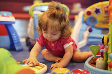 Baby girl playing with toys in a playroom of cruise liner - SHKF000085