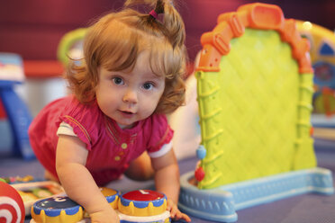 Baby girl playing with toys in a playroom of cruise liner - SHKF000086