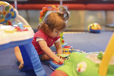 Baby girl playing with toys in a playroom of cruise liner - SHKF000099