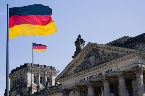 Deutschland, Berlin, Blick auf den oberen Teil des Reichstagsgebäudes mit zwei deutschen Fahnen - PSF000664