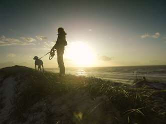Dänemark, Nordjütland, Frau mit Hund am Strand - ONF000651
