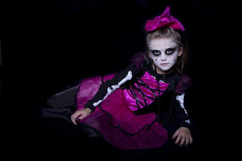 Kleines Mädchen Maskerade als moderne untote Hexe vor schwarzem Hintergrund liegend - YFF000256