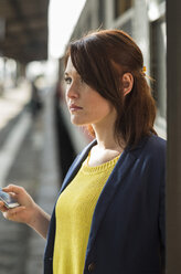 Young woman with cell phone at train station - UUF002496