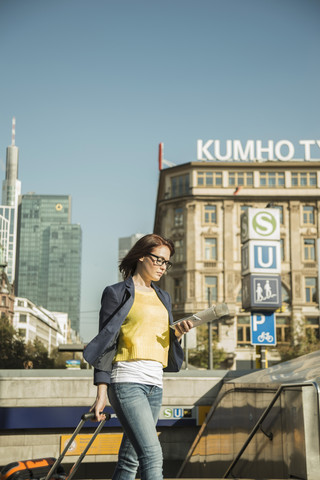 Deutschland, Frankfurt, junge Geschäftsfrau in der Innenstadt unterwegs, lizenzfreies Stockfoto