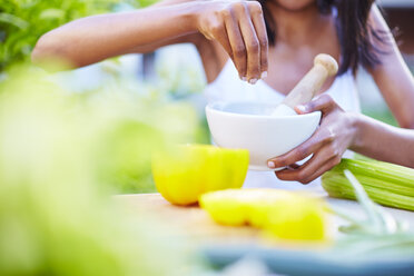 Junge Frau bei der Zubereitung einer gesunden Mahlzeit im Garten - ZEF001793