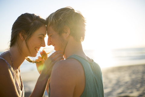 Junges Paar, das einen Moment am Strand verbringt, lizenzfreies Stockfoto