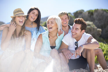 Friends socializing with laughter on the beach - ZEF002377