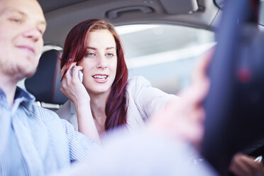 Couple at car dealer examing car interior - ZEF002034