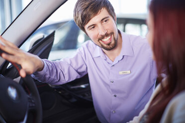 Car dealer talking to client inside car - ZEF002037