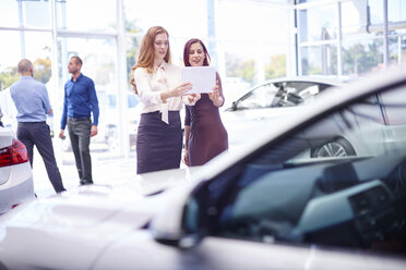 Zwei Frauen im Autohaus mit digitalem Tablet - ZEF002057