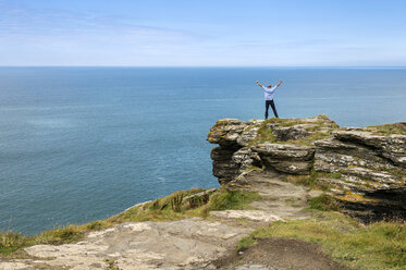 Vereinigtes Königreich, England, Cornwall, Tintagel, Nordküste, Tourist steht auf Felsen - FRF000086