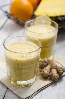 Zwei Gläser Apfel-Ananas-Smoothie und Ingwerwurzel auf Tuch - ODF000857