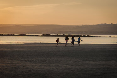 UK, England, Cornwall, children running on beach at sunset - PAF001051