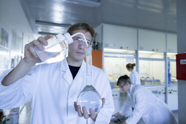 Drei Chemiker arbeiten in einem Chemielabor - SGF000972