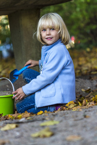Porträt eines kleinen Mädchens, das mit Sandkastenspielzeug spielt, lizenzfreies Stockfoto