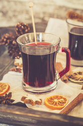 Glasses of mulled wine, orange slices and cinnamon stars on cloth and wooden tray - SARF000982