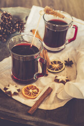 Glasses of mulled wine, orange slices and cinnamon stars on cloth and wooden tray - SARF000984