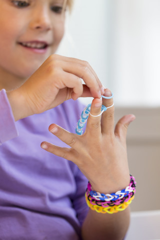 Kleines Mädchen macht Loom-Armbänder, lizenzfreies Stockfoto