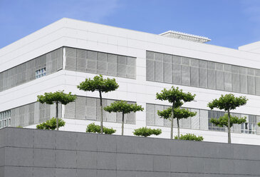 Deutschland, Nordrhein-Westfalen, Neuss, Teil der Fassade eines weißen modernen Bürogebäudes mit Bäumen davor - GUFF000012