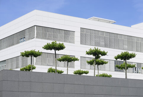 Deutschland, Nordrhein-Westfalen, Neuss, Teil der Fassade eines weißen modernen Bürogebäudes mit Bäumen davor - GUFF000012