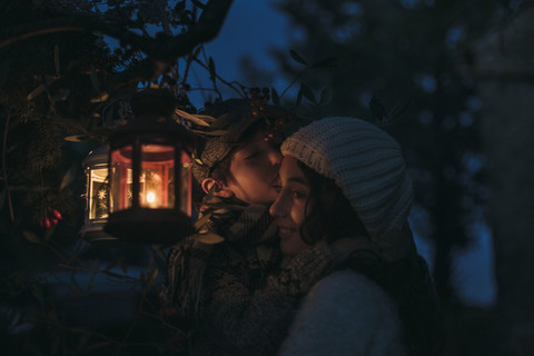 Italien, Grosseto, Geschwister mit beleuchteter Weihnachtslaterne bei Nacht, lizenzfreies Stockfoto