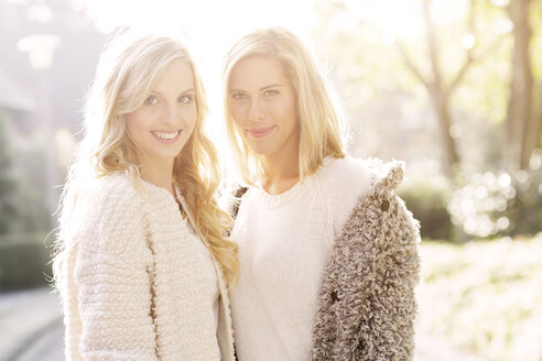 Portrait of two smiling blond women at backlight - GDF000554