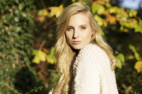 Portrait of blond woman in front of autumn leaves - GDF000566