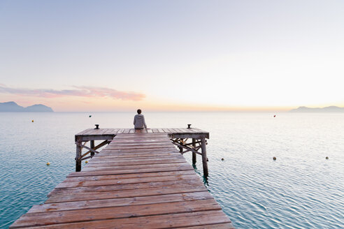 Spain, Balearic Islands, Majorca, one teenage boy sitting on a jetty in the morning - MSF004342