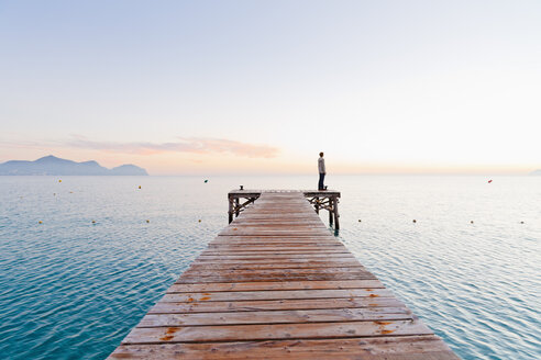 Spain, Balearic Islands, Majorca, one teenage boy standing on jetty in the morning - MSF004344