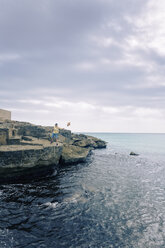 Spanien, Balearische Inseln, Mallorca, ein Jugendlicher wirft einen Stein ins Meer - MSF004363