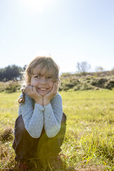 Smiling girl crouching on a meadow - OJF000060