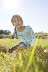 Smiling girl sitting on a meadow - OJF000061