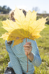 Girl hiding behind autumn leaf - OJF000062