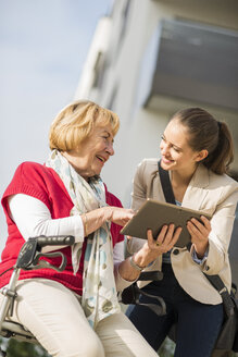 Enkelin und ihre Großmutter mit digitalem Tablet - UUF002566