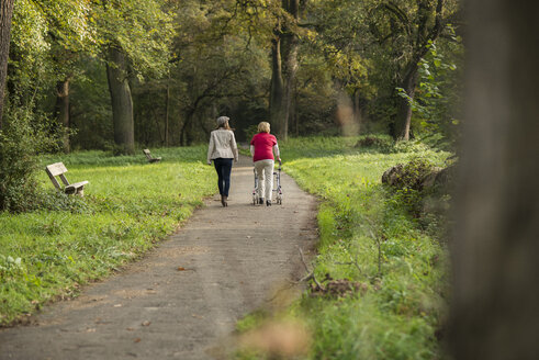 Ältere Frau und Enkelin gehen zusammen in einem Park spazieren, Rückenansicht - UUF002573