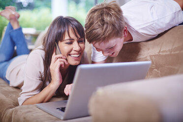 Mother and son at home using laptop - ZEF002268