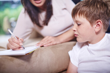 Mother and son in living room with pen and paper - ZEF002272