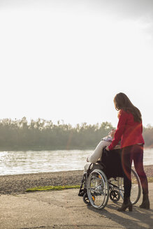 Erwachsene Enkelin, die ihrer im Rollstuhl sitzenden Großmutter hilft - UUF002589