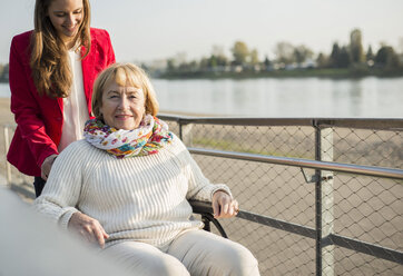Enkelin, die ihrer im Rollstuhl sitzenden Großmutter hilft - UUF002601