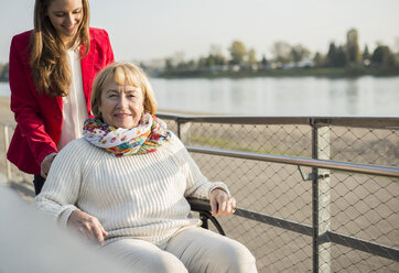 Granddaughter assisting her grandmother sitting in wheelchair - UUF002601