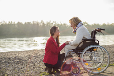 Granddaughter assisting her grandmother sitting in wheelchair - UUF002603